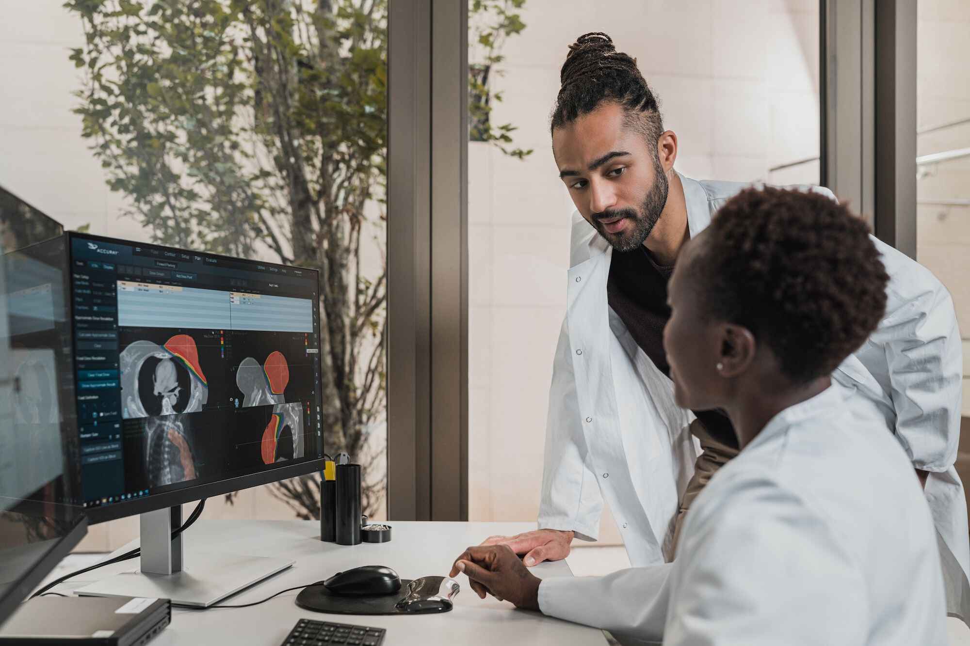 two doctors discussing in front of computer screen