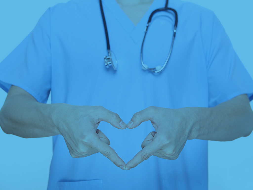 a medical professional showing a heart with his hands